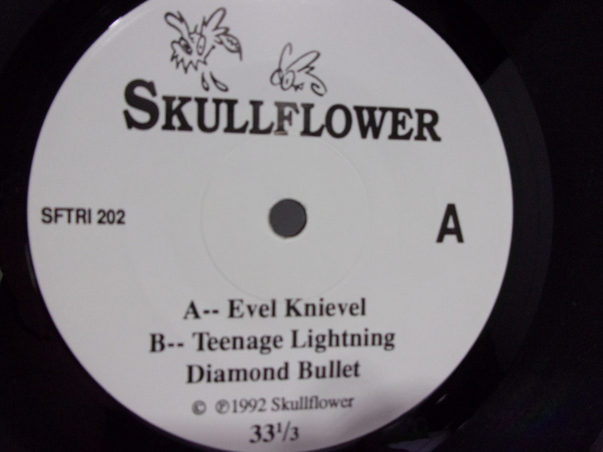 Close-up view of the Skullflower: Evel Knievel SFTRI 202 7" single vinyl record label, detailing tracks 'Evel Knievel', 'Teenage Lightning', and 'Diamond Bullet'.