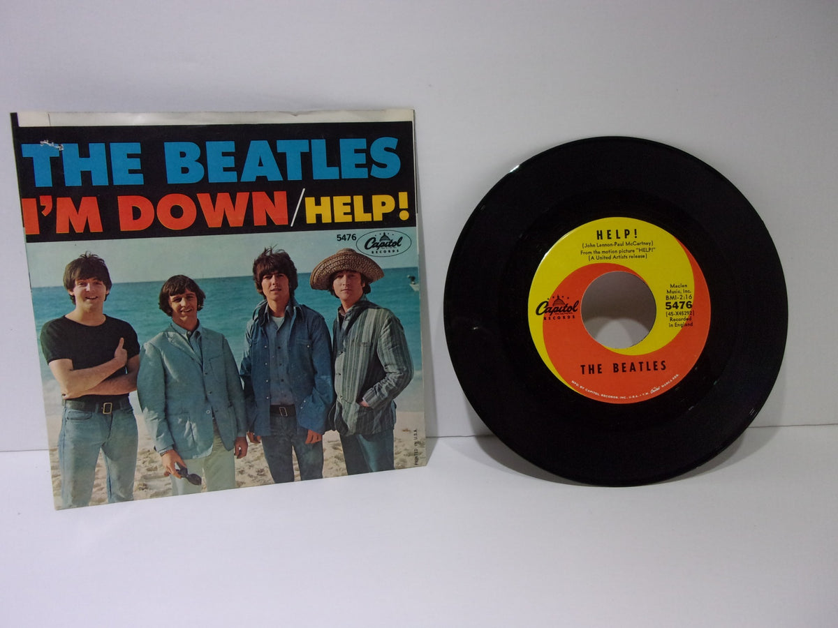 The Beatles: Help! / I’m Down Capitol Records 5476 Single 7" 45RPM displayed alongside its cover, featuring the band on a beach.