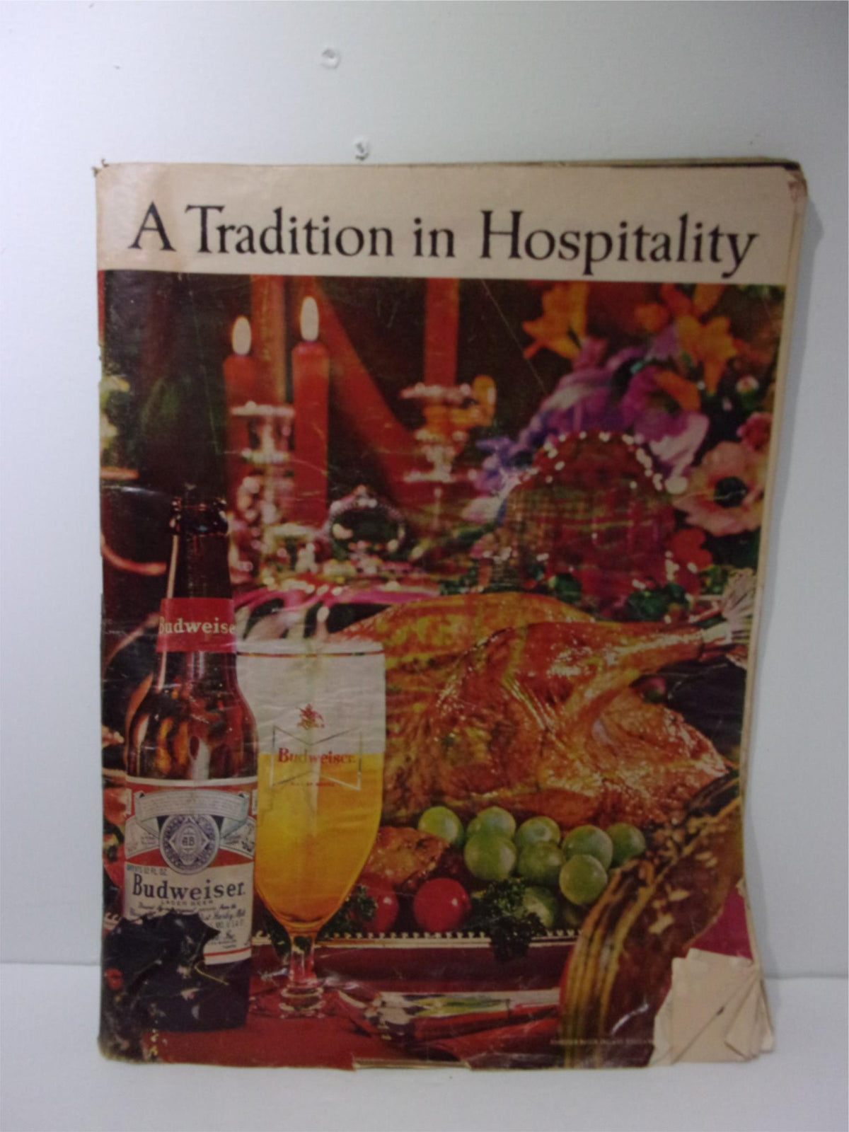 1963 Budweiser Magazine Ad showcasing a festive setting with food, drinks, and a warm atmosphere, emphasizing 'A Tradition in Hospitality'.