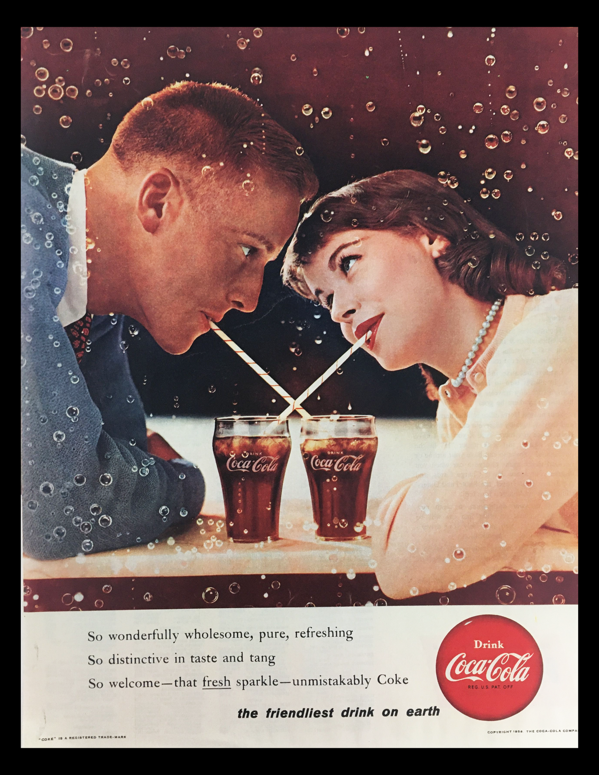 1956 Coca-Cola Fresh Sparkle Coke Vintage Print Ad featuring a romantic couple sharing a drink through two straws, surrounded by bubbles, showcasing the nostalgic essence of Coca-Cola during the mid-20th century.