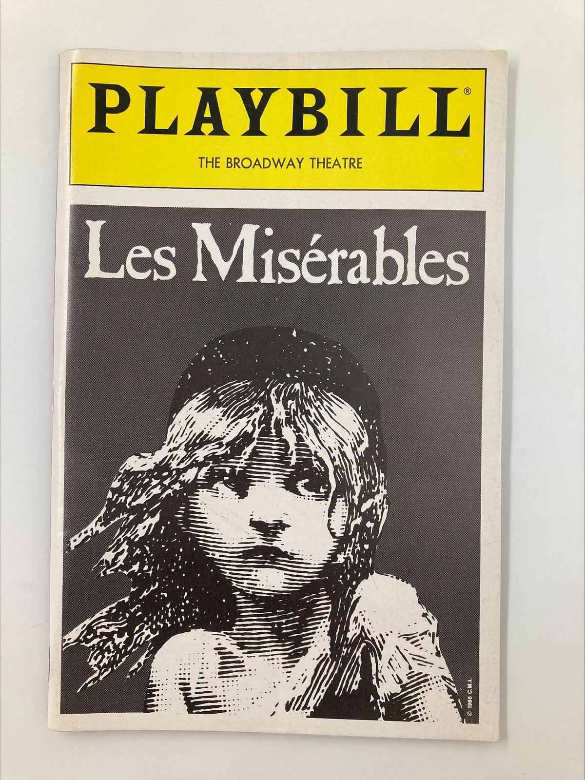 1989 Playbill for the Broadway Theatre production of Les Misérables by Cameron Mackintosh, featuring a striking black and white illustration of a young girl with long hair, capturing the essence of the famous musical.