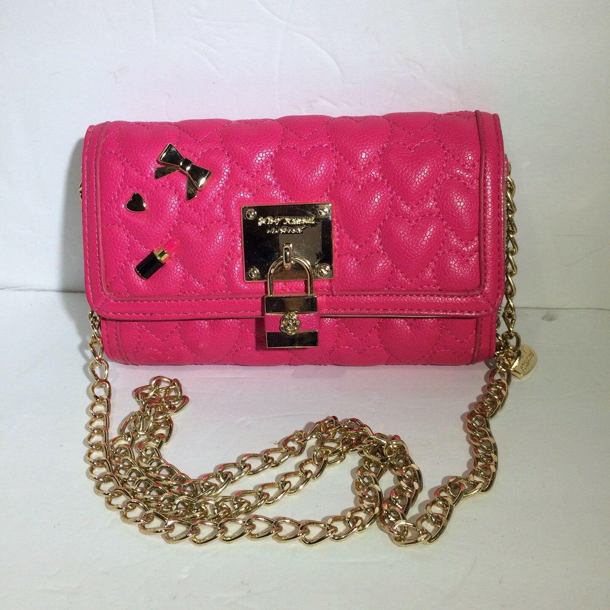 Betsey Johnson Pink & Gold Chain Purse Bag Quilted Heart Lock Bow Lipstick, featuring a vibrant pink exterior with a heart quilted pattern, decorative bow and heart charms.