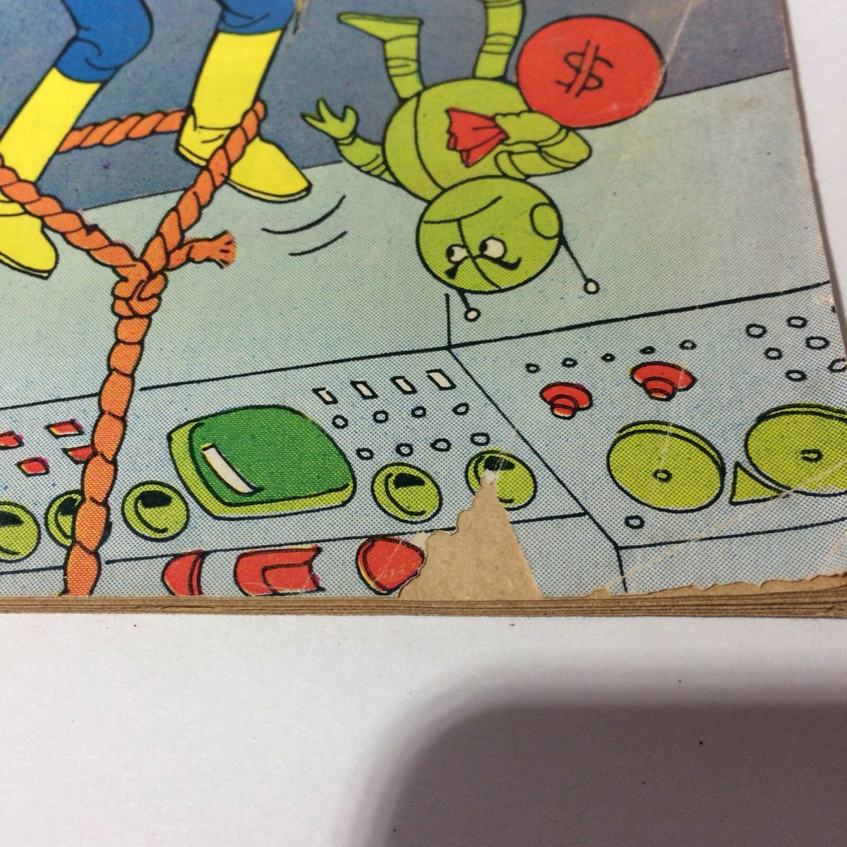 Super Richie #4 Collectible Vintage Comic Harvey World 'Peculiar Vandalism' capturing a worn page corner with a visible tear and cartoon character holding a bag marked with a dollar sign.
