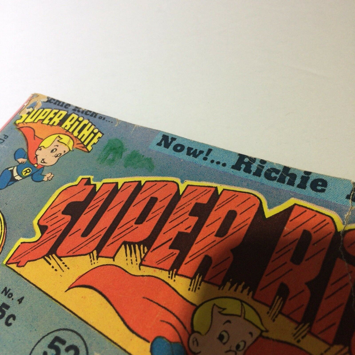 Super Richie #4 Collectible Vintage Comic Harvey World 'Peculiar Vandalism' highlighting the comic's title and small damage on the cover.