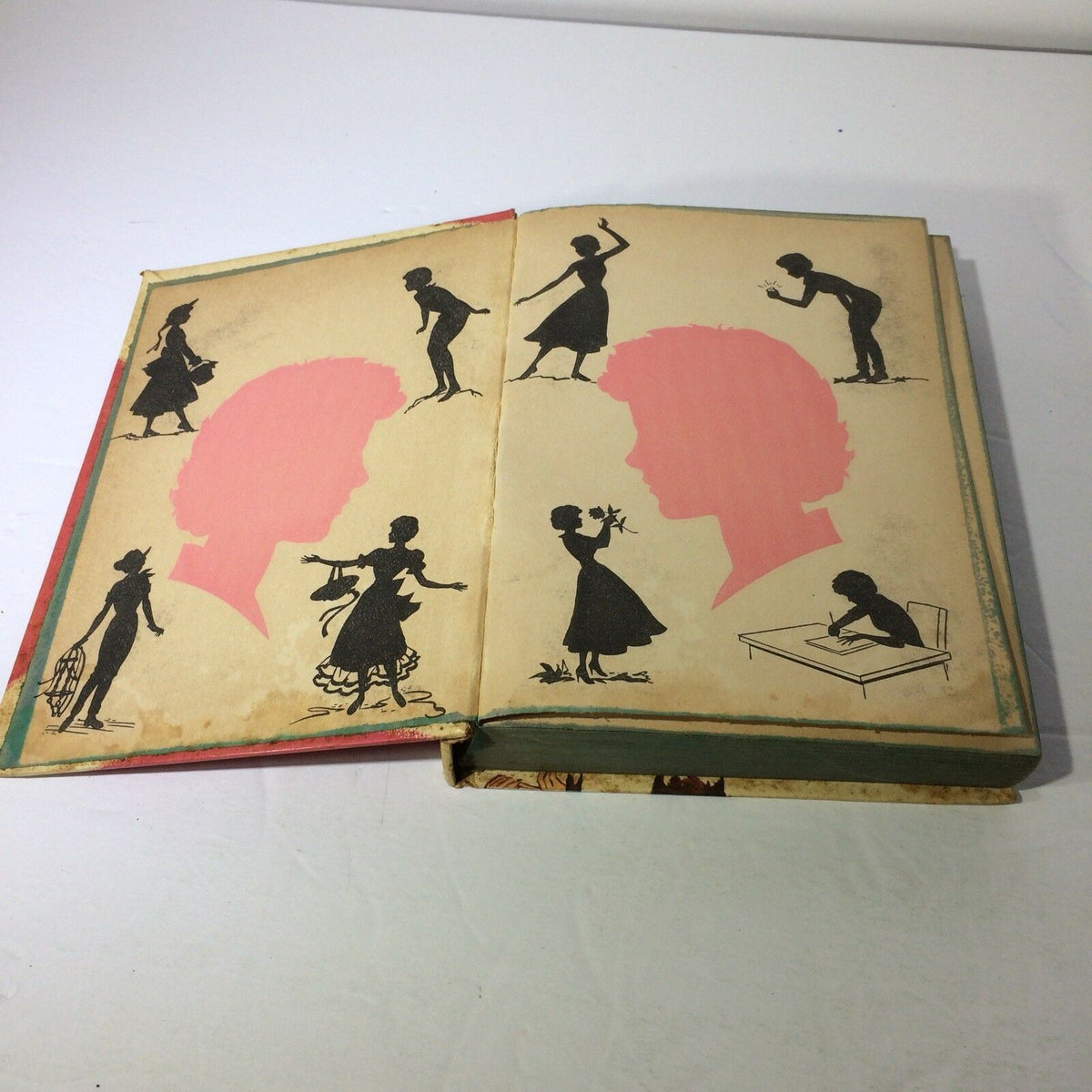 Interior view of two vintage Walt Disney's Annette Books with silhouettes of dancers and children on aged pages in light colors, showcasing 'Mystery at Moonstone Bay' and 'Sierra Summer'.
