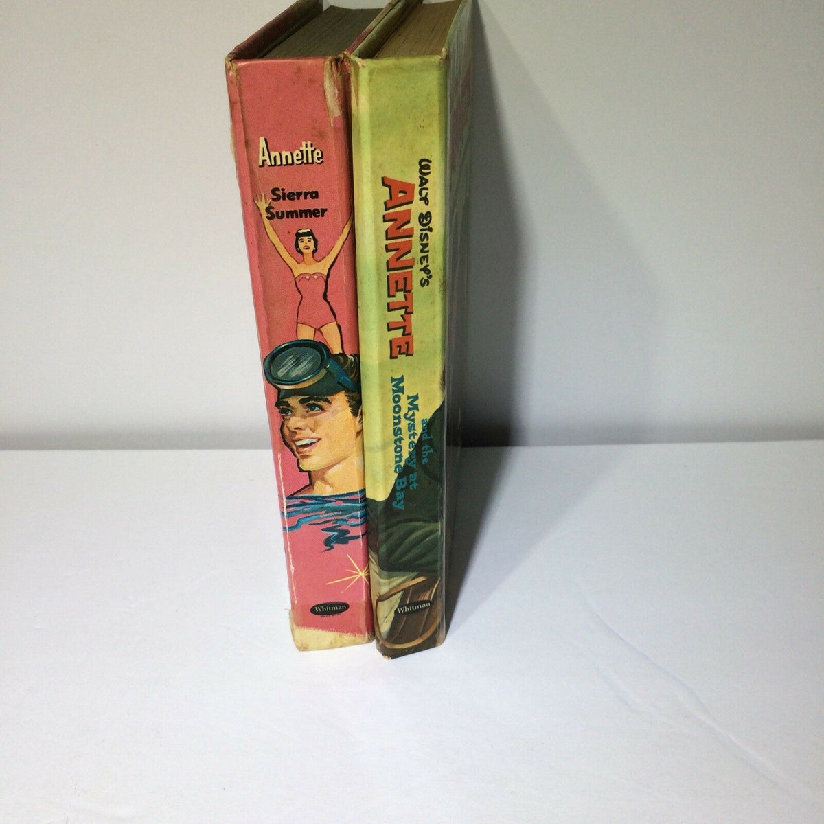 Side view of two vintage Walt Disney's Annette Books titled 'Annette' and 'Mystery at Moonstone Bay', featuring vibrant front covers that capture classic Disney charm.