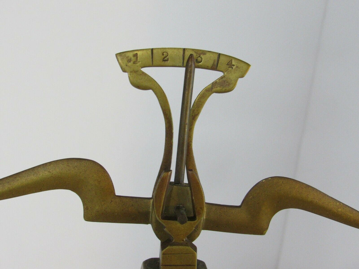 Close-up view of the vintage antique brass weight scale balance, highlighting the measurement indicator.