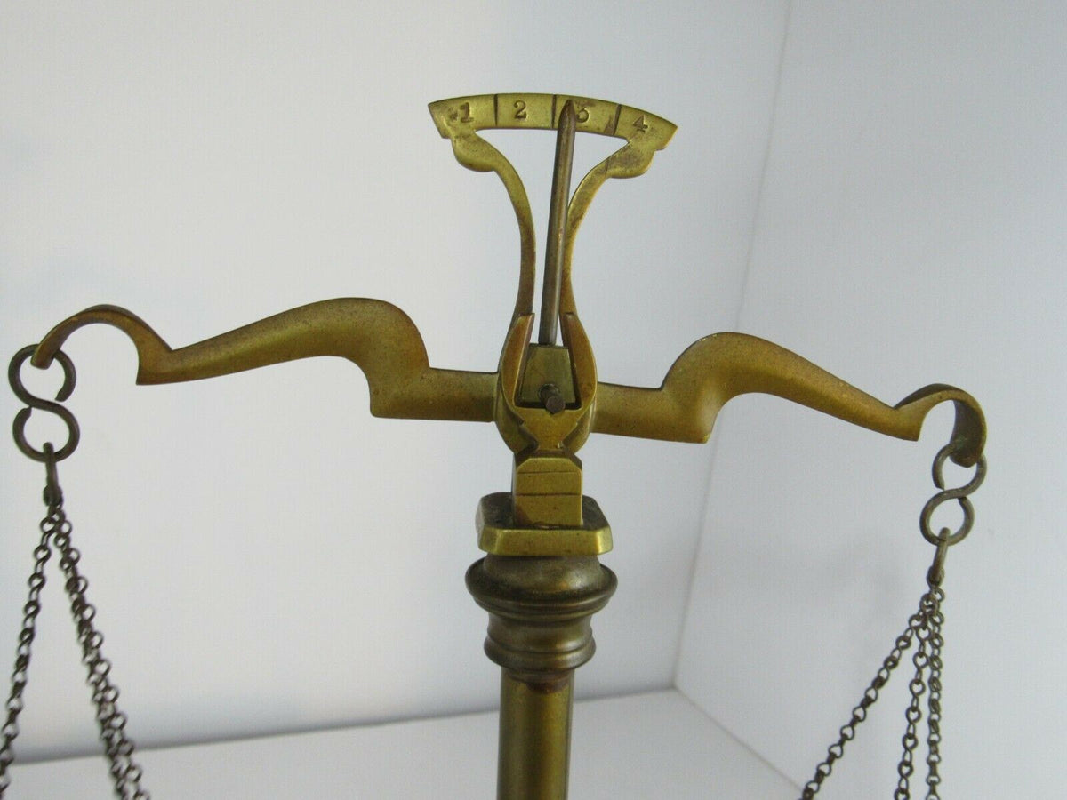 Detailed angle of vintage antique brass weight scale balance, emphasizing the beautifully crafted arms.