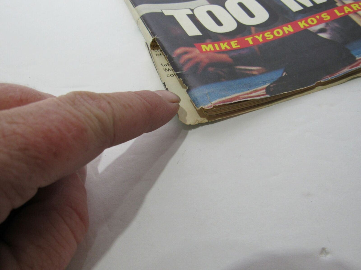 Close-up of the torn binding of Sports Illustrated February 1, 1988, showcasing the condition of the magazine featuring Mike Tyson KO's Larry Holmes.