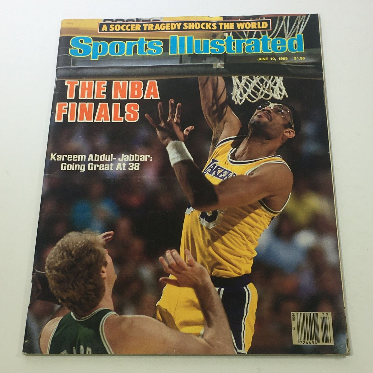 Cover of Sports Illustrated: June 10, 1985, featuring Kareem Abdul-Jabbar at age 38 during the NBA Finals, showcasing his iconic slam dunk with a player from the opposing team in the foreground.
