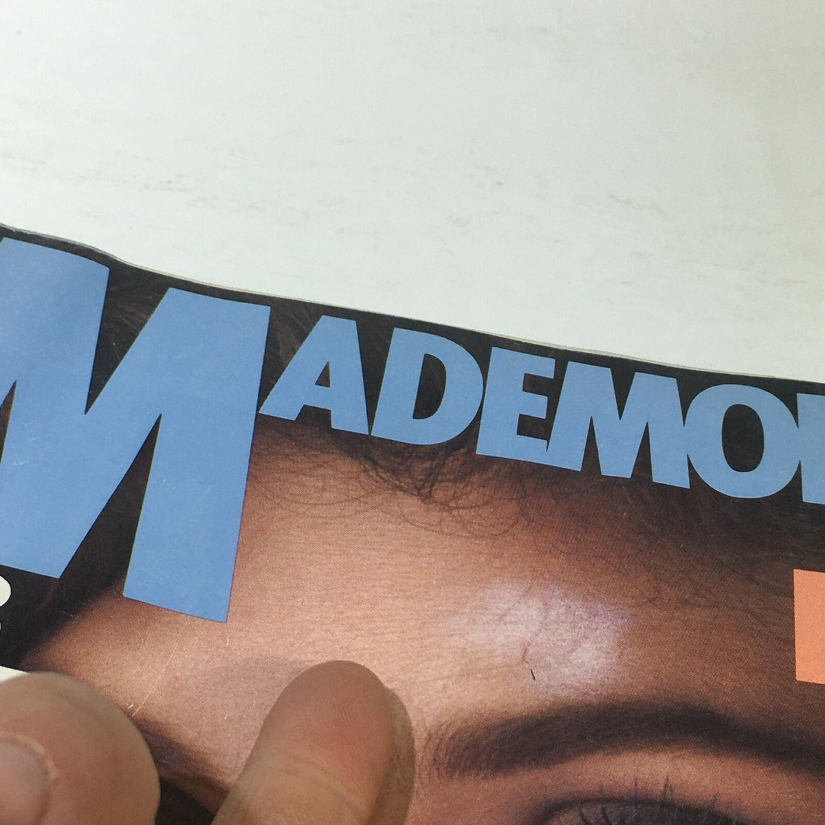 Close-up of the Vintage Mademoiselle Magazine's April 1983 cover featuring bold letters, showing part of the title 'MADEMOISELLE' and highlighting the vintage aesthetic.