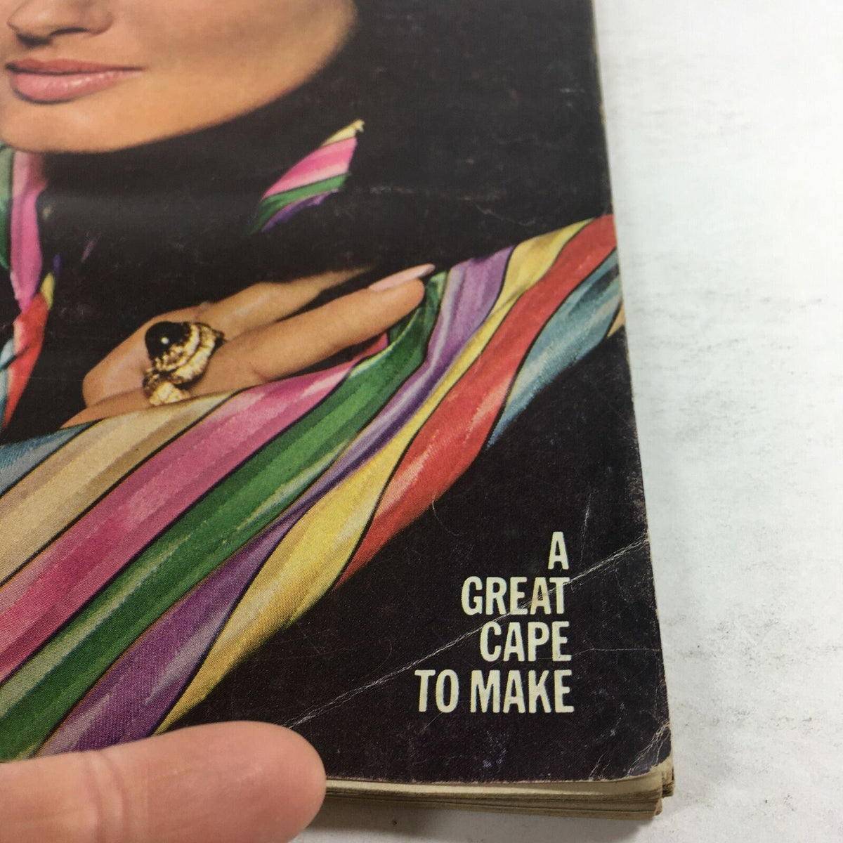 Close-up of the VTG McCall's Magazine: December 1971 cover, highlighting the text 'A Great Cape to Make' alongside a woman wearing a vibrant striped cape.
