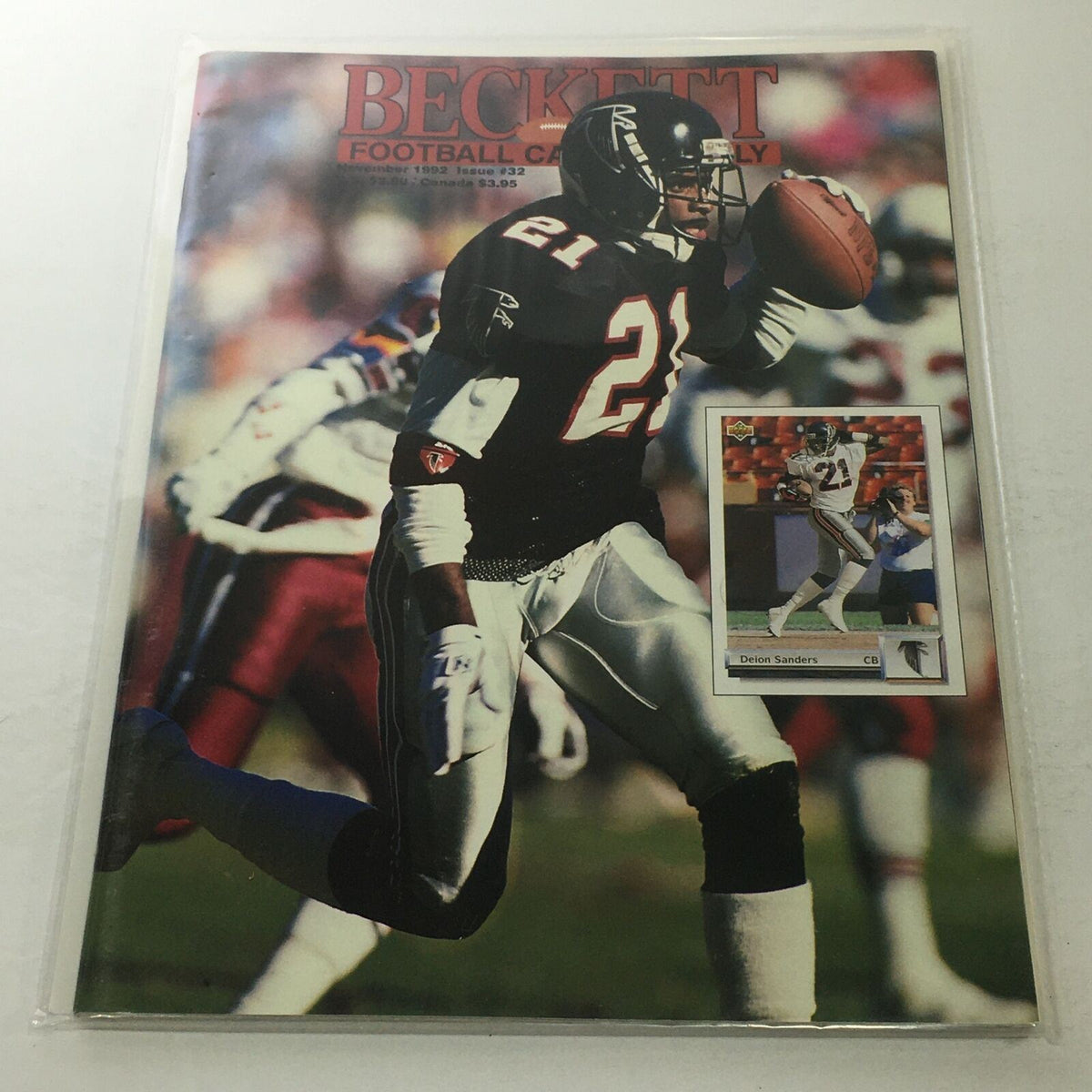 Beckett Football Card Monthly: November 1992 Issue #32 featuring Delon Sanders on the cover, showcasing the player in action with football gear, alongside a featured card in a protective sleeve.