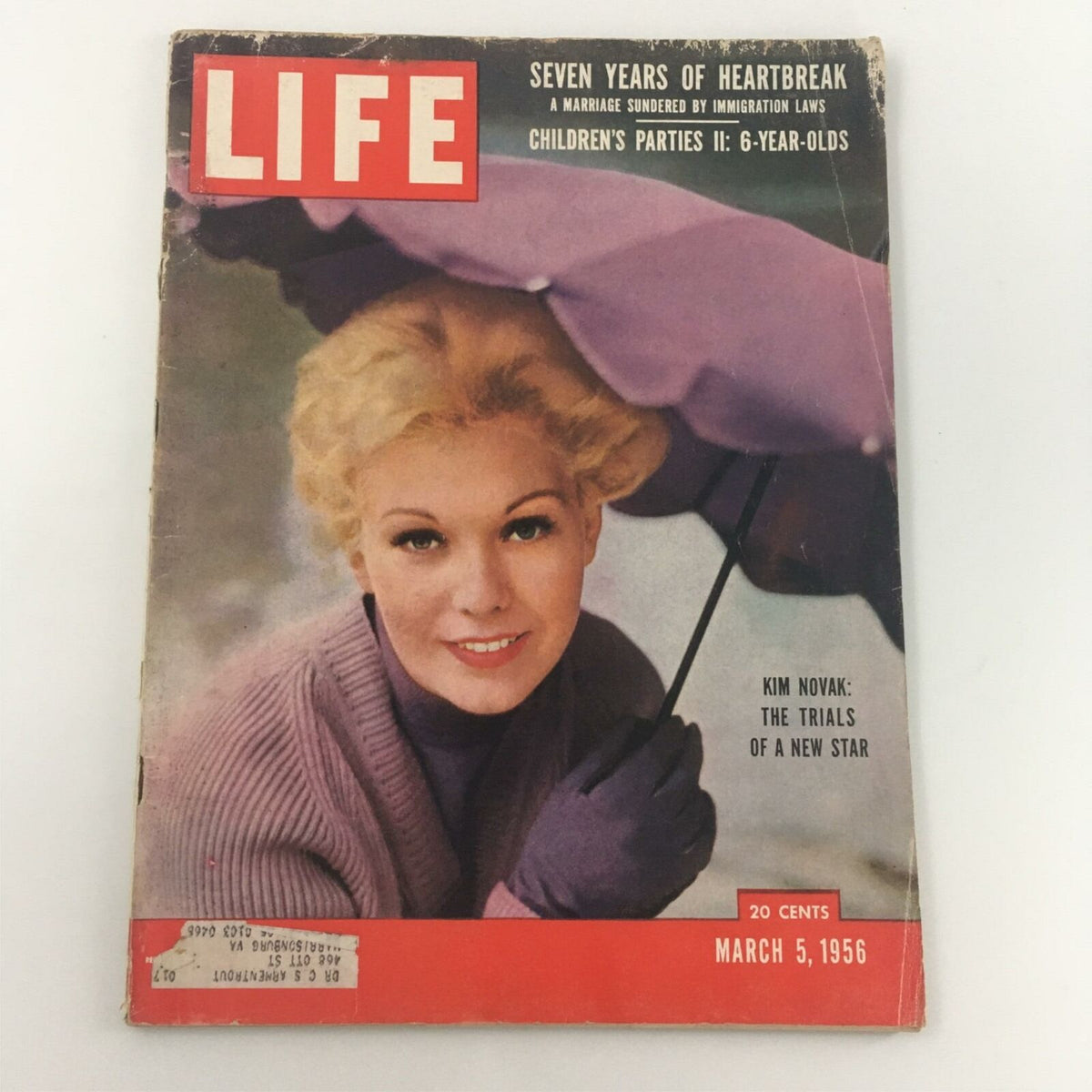 Cover of VTG Life Magazine, March 5, 1956, featuring Kim Novak, titled 'The Trials of a New Star', showcasing the actress smiling under an umbrella with a retro aesthetic.