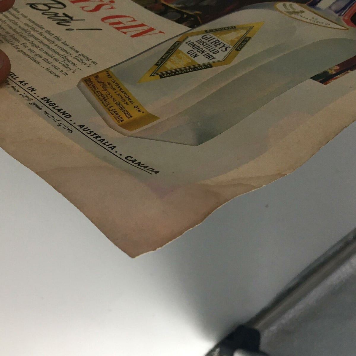 Close-up view of an advertisement page from vintage Life Magazine, featuring Gilbey's London Dry Gin, illustrating classic 1940s product marketing.