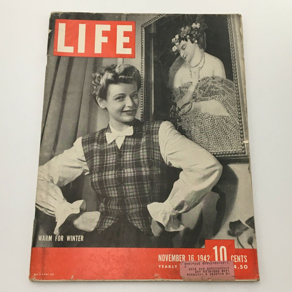 VTG Life Magazine November 16 1942 cover featuring a woman dressed in a plaid vest with a charming expression, alongside artwork in the background, showcasing a 'Warm For Winter' theme.