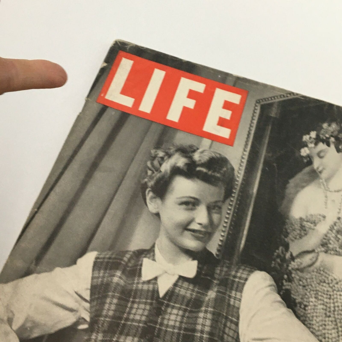 Close-up of VTG Life Magazine November 16 1942 cover highlighting the title 'LIFE' and the image of a woman in a plaid vest with a playful smile, part of the 'Warm For Winter' feature.