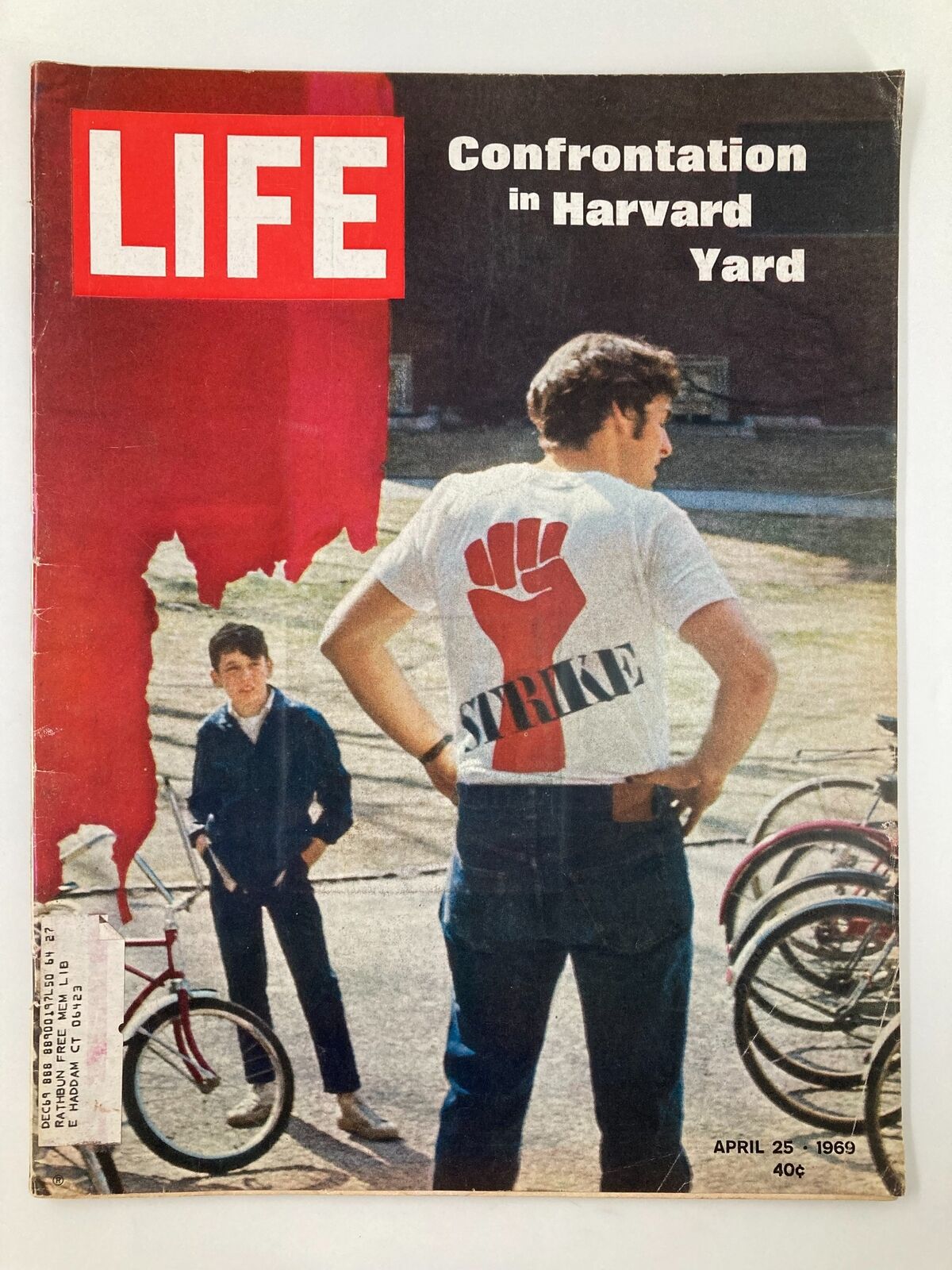 VTG Life Magazine April 25 1969 featuring the cover story 'Confrontation in Harvard University Yard', showcasing two young men in Harvard Yard, one wearing a shirt with the word 'STRIKE' and a raised fist symbol, amidst bicycles, reflecting a moment of social change in the 1960s.