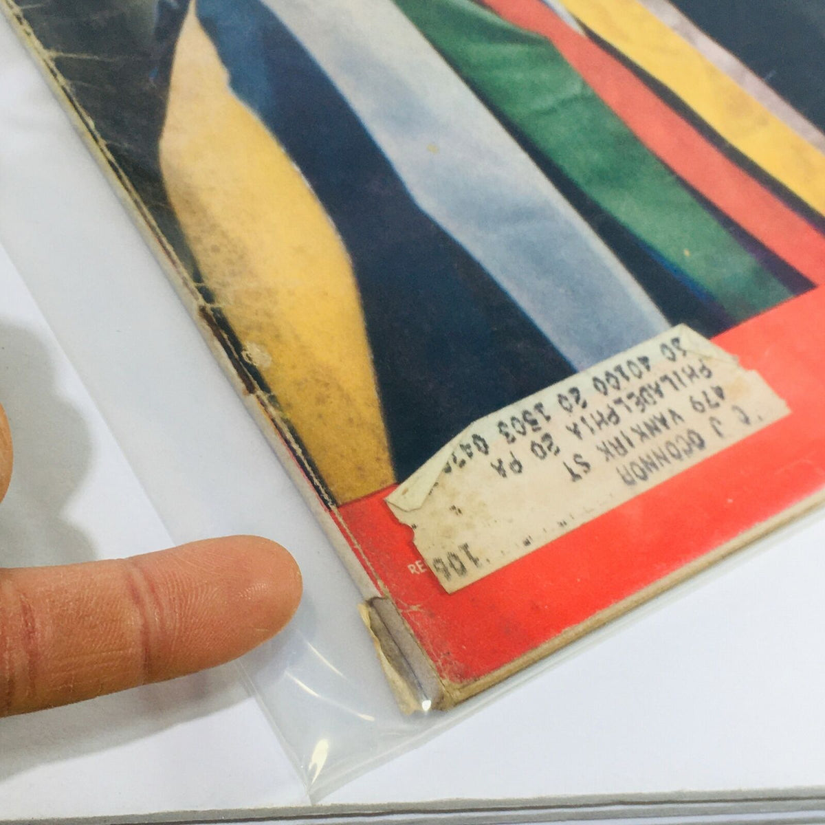 Close-up view of the lower edge of the VTG Life Magazine Cover July 9, 1956, showing the wear and tear along with a label attached.
