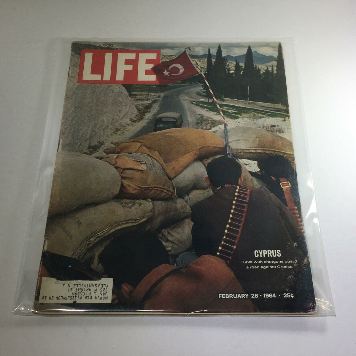 VTG Life Magazine cover from February 28, 1964, featuring a scene in Cyprus where Turks with shotguns guard a road. The image shows armed individuals behind sandbags with a Turkish flag in view.