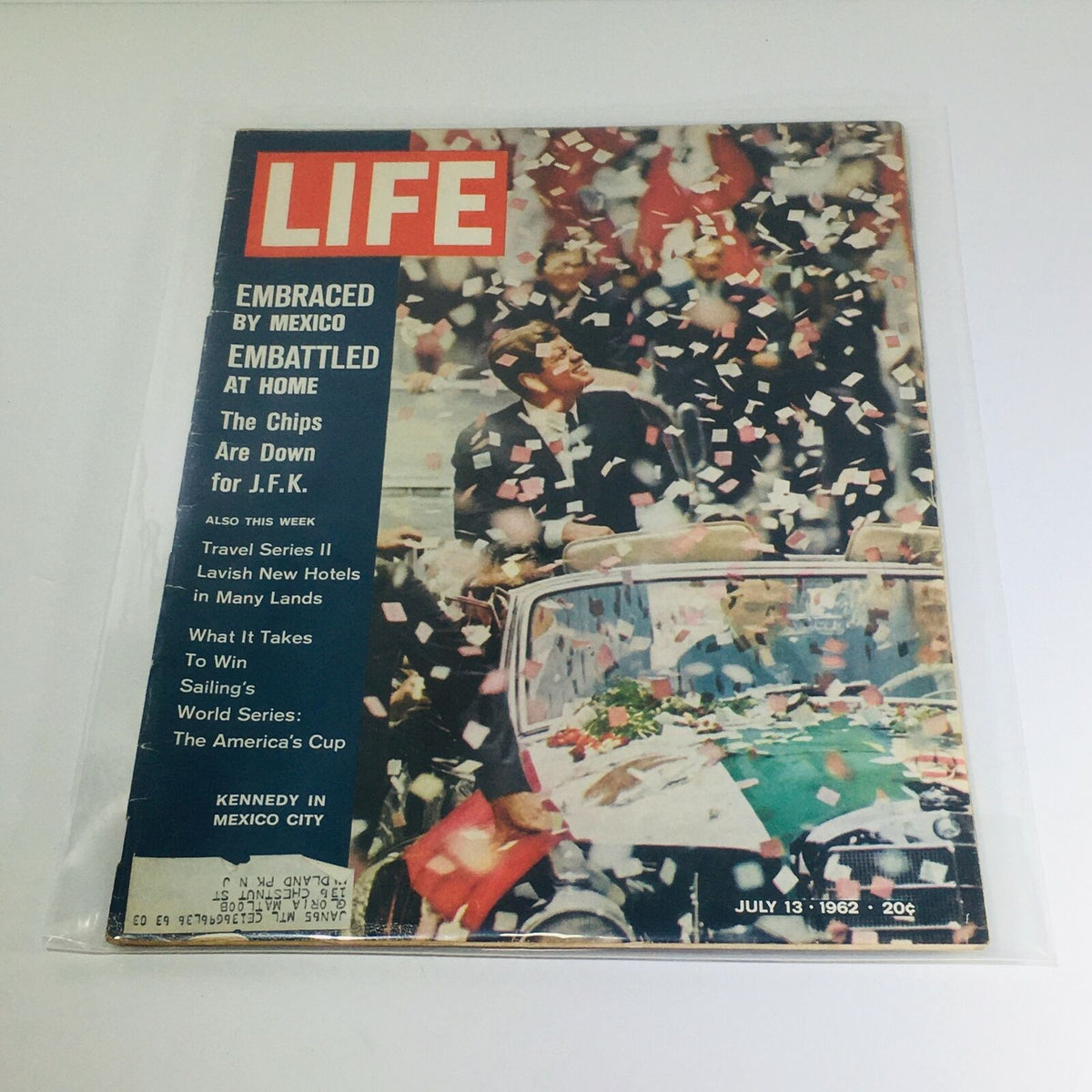 VTG Life Magazine cover from July 13, 1962 featuring John F. Kennedy in Mexico City. The cover displays vibrant colors and confetti, showcasing the theme 'Embraced by Mexico, Embattled at Home' alongside intriguing headlines, perfect for collectors of vintage magazines.