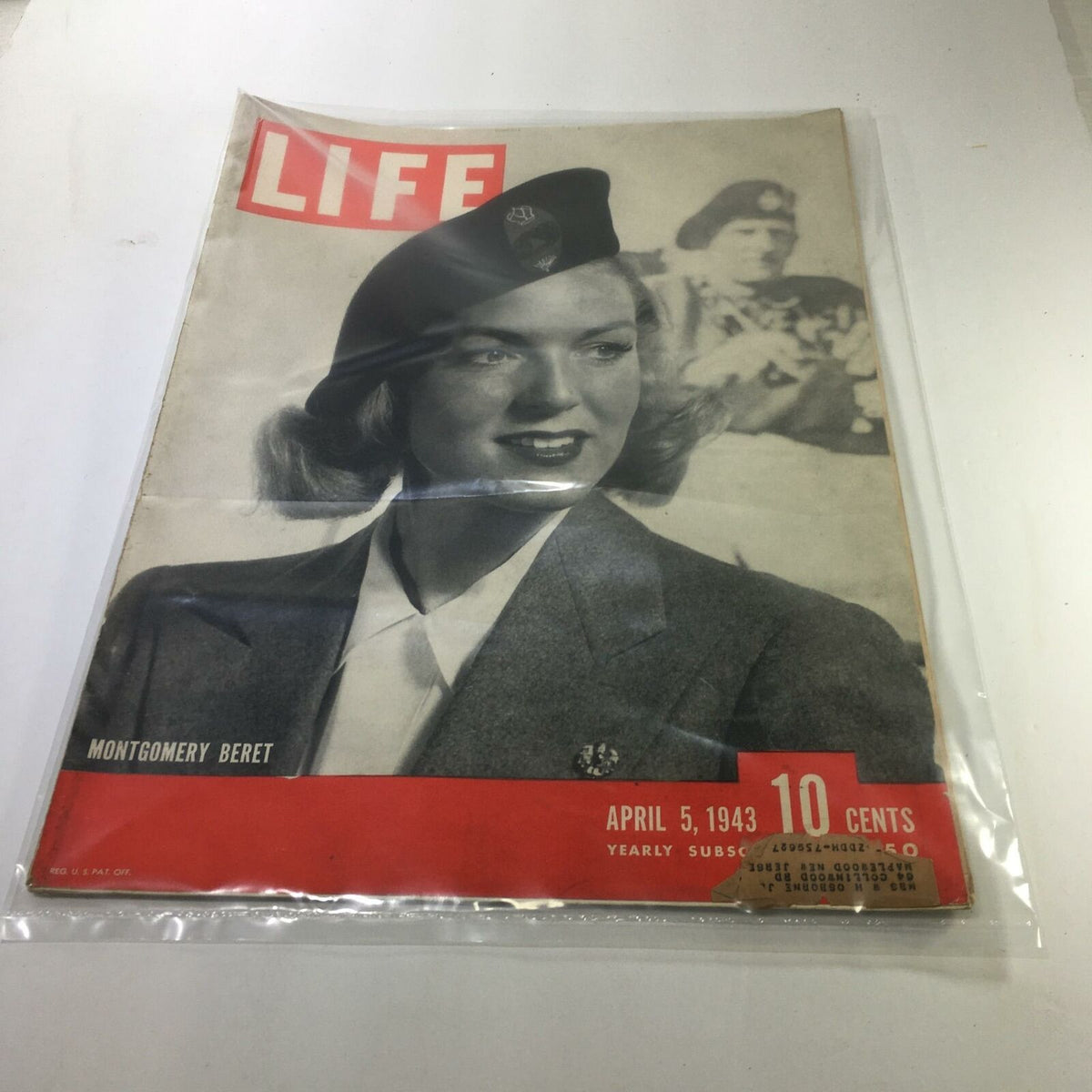 VTG Life Magazine dated April 5, 1943 featuring the Montgomery Beret on the cover, showcasing a vintage image with a woman in a beret and military-style outfit, preserved in a plastic protective covering.