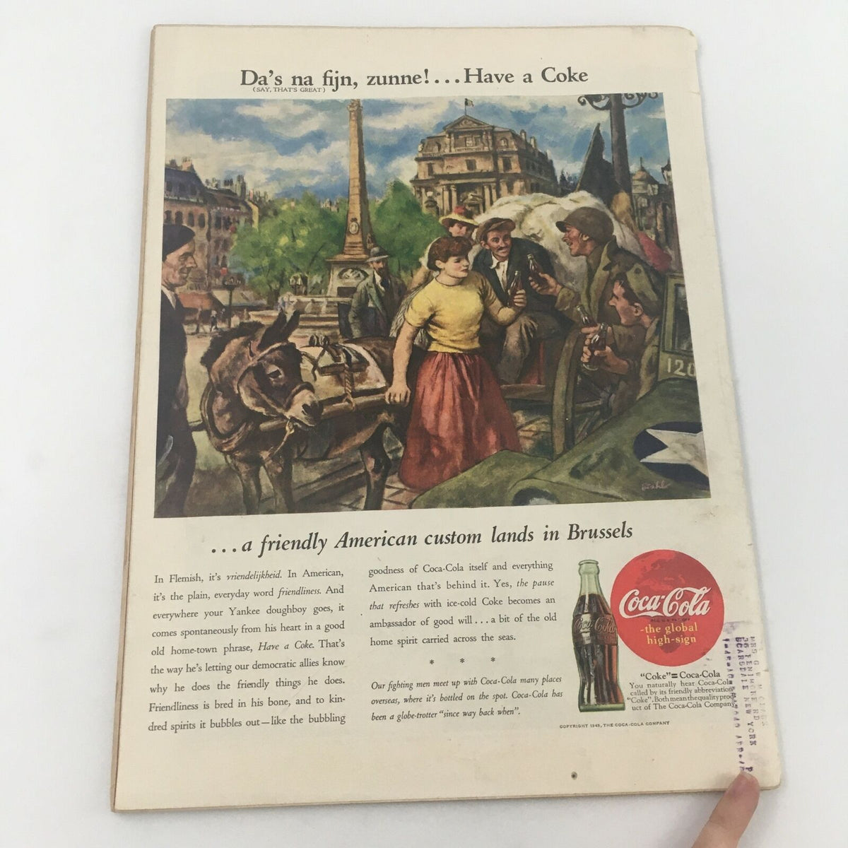 Back cover of the VTG Life Magazine from June 4, 1945, showcasing a colorful Coca-Cola advertisement with a lively scene in Brussels, highlighting wartime camaraderie and American culture.