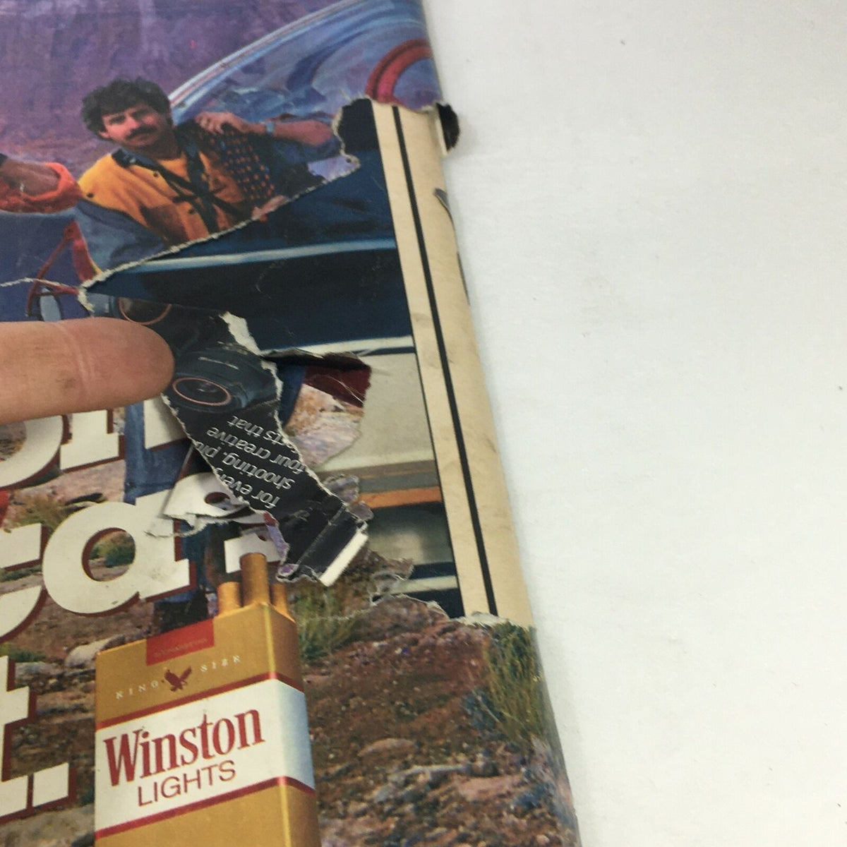 Close-up view of the damaged cover of VTG Life Magazine May 1985 featuring the Bill Schroeder Artificial Heart Medical Experiment, showcasing the wear and tear on the edges and a prominent tear. This vintage magazine captures significant medical history.