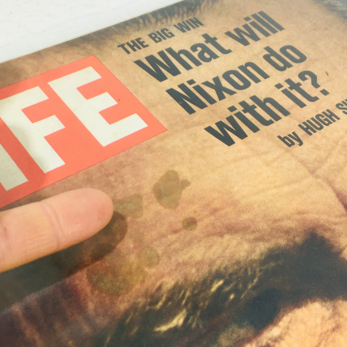 Detail view of the cover of VTG Life Magazine: November 17 1972 highlighting the title 'The Big Win: What Will Nixon Do With It?' with a finger pointing at imperfections, emphasizing the magazine's historical condition.