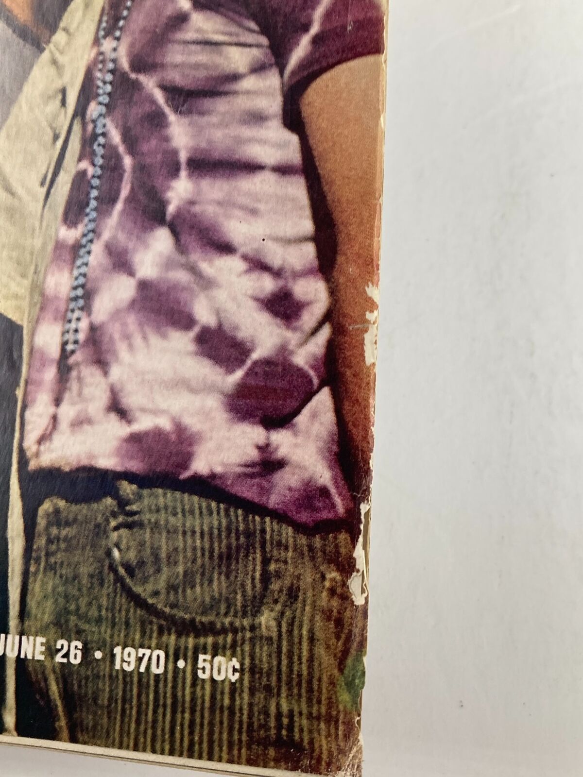 Close-up of the side of the VTG Life Magazine June 26 1970 showcasing the detail of a tie-dye shirt worn by one of the men on the cover, emphasizing its vintage style.