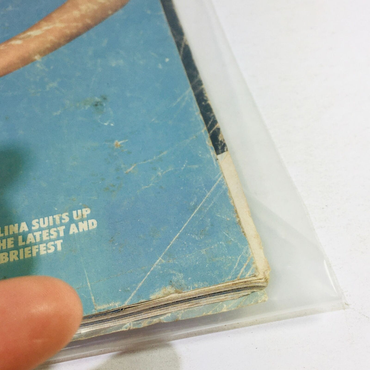 Close-up view of the edge of the VTG Life Magazine February 1986 edition, showing signs of wear and a protective plastic covering, emphasizing the vintage appeal of the magazine featuring Paulina Suits Up Bathing Beauties.