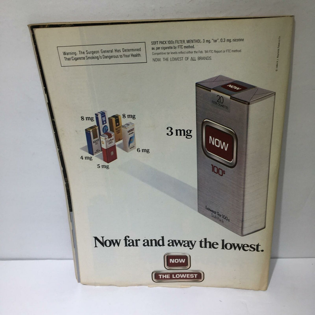 Vintage advertisement for Now cigarettes, featuring details about tobacco content and a visual of various cigarette packs, accompanying the Time Magazine December 10, 1984, issue on medical miracles.