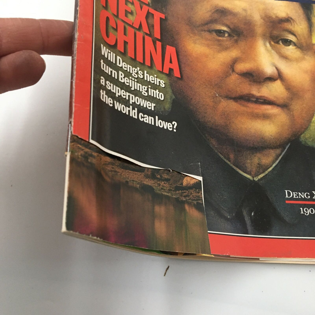 Close-up of the Time Magazine March 3, 1997 cover featuring Deng Xiaoping, showing corner wear and damage while highlighting the text 'The Next China' and questions regarding the future leadership of China.