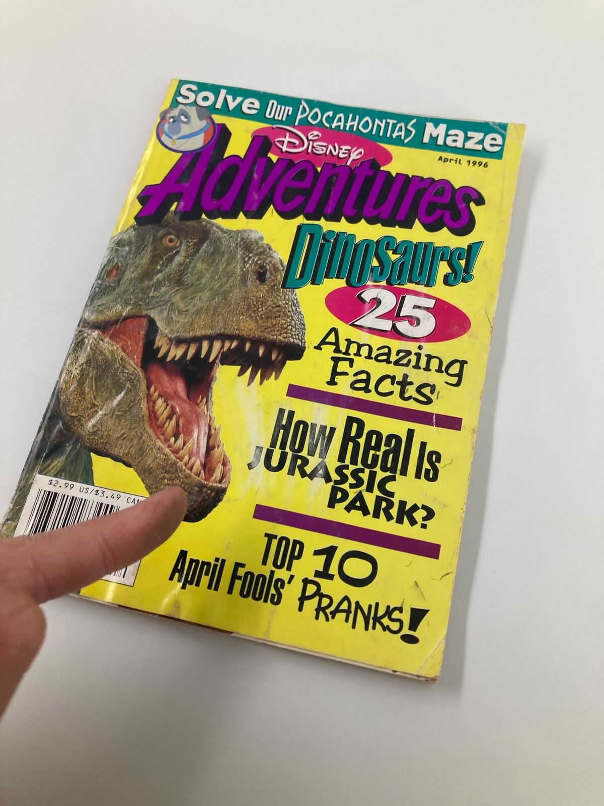 Disney Adventures Magazine April 1996 cover showing a T-Rex with text about dinosaurs and features like 'How Real is Jurassic Park?' and 'Top 10 April Fools' Pranks'.