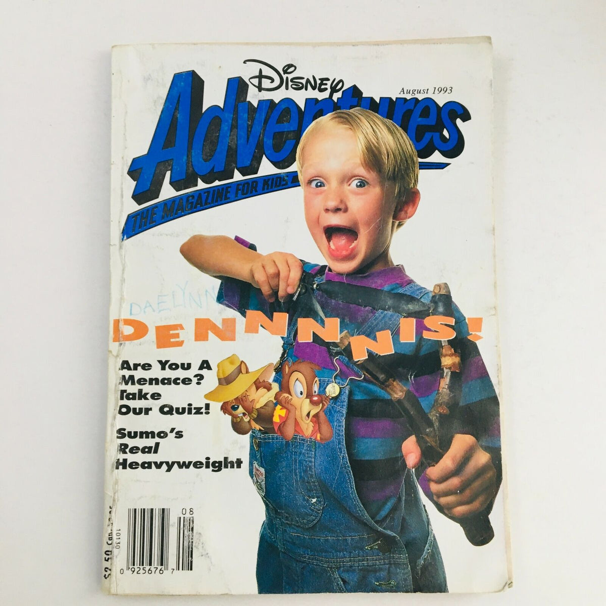 Cover of Disney Adventures Magazine, August 1993 featuring Dennis the Menace and Chip & Dale. A young boy joyfully poses with a slingshot, highlighting the magazine's nostalgic focus on iconic characters for kids.