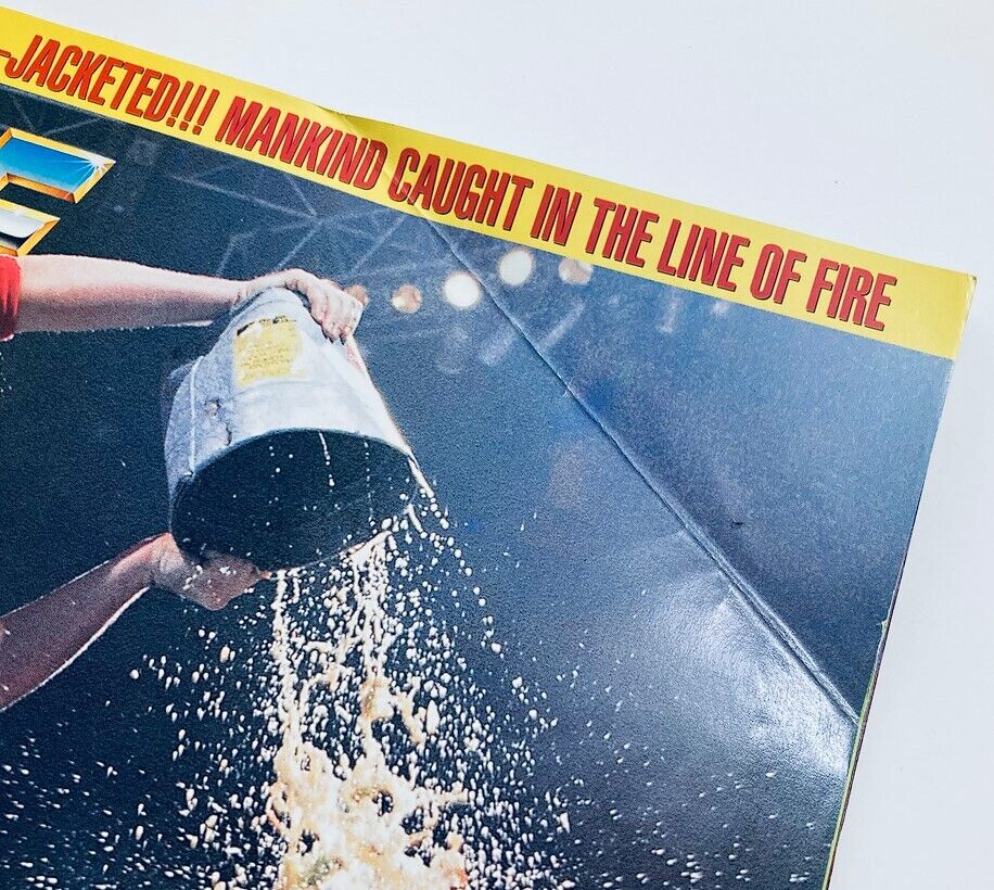 WWF World Wrestling Federation Magazine September 1996 featuring a close-up shot of a character pouring liquid from a metal bucket, with the words 'CAUGHT IN THE LINE OF FIRE' prominently displayed.