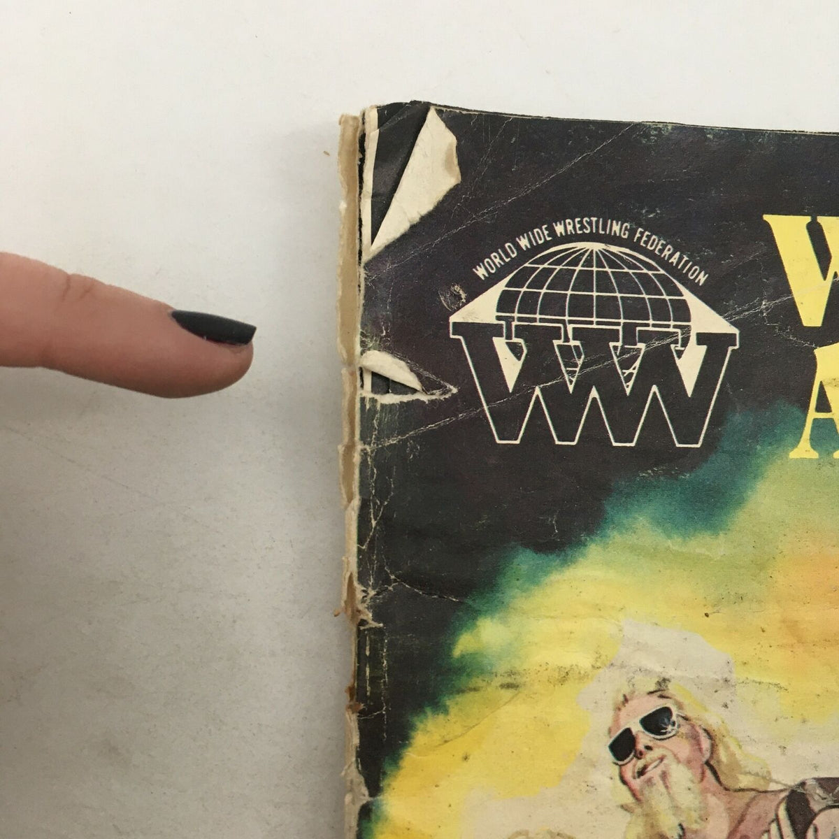 Side view of Wrestling Action Magazine Vol 1 #4 highlighting wear and tear, including tears and scuff marks, showcasing its age.
