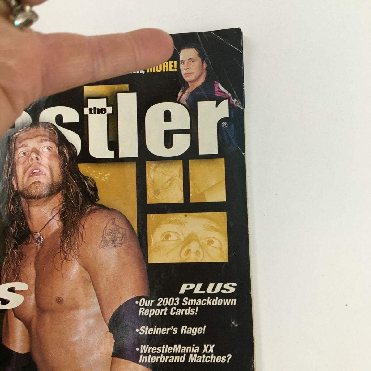 Detailed view of the cover of The Wrestler Magazine May 2004, emphasizing the section 'Plus Our 2003 Smackdown Report Cards' and a sneak peek into featured wrestlers.