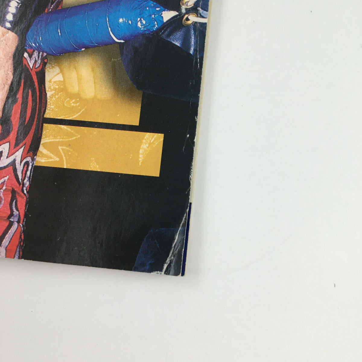 Close-up of the edge of The Wrestler Magazine May 2004, showing minor wear and tear typical of vintage magazines while displaying its striking graphic design.