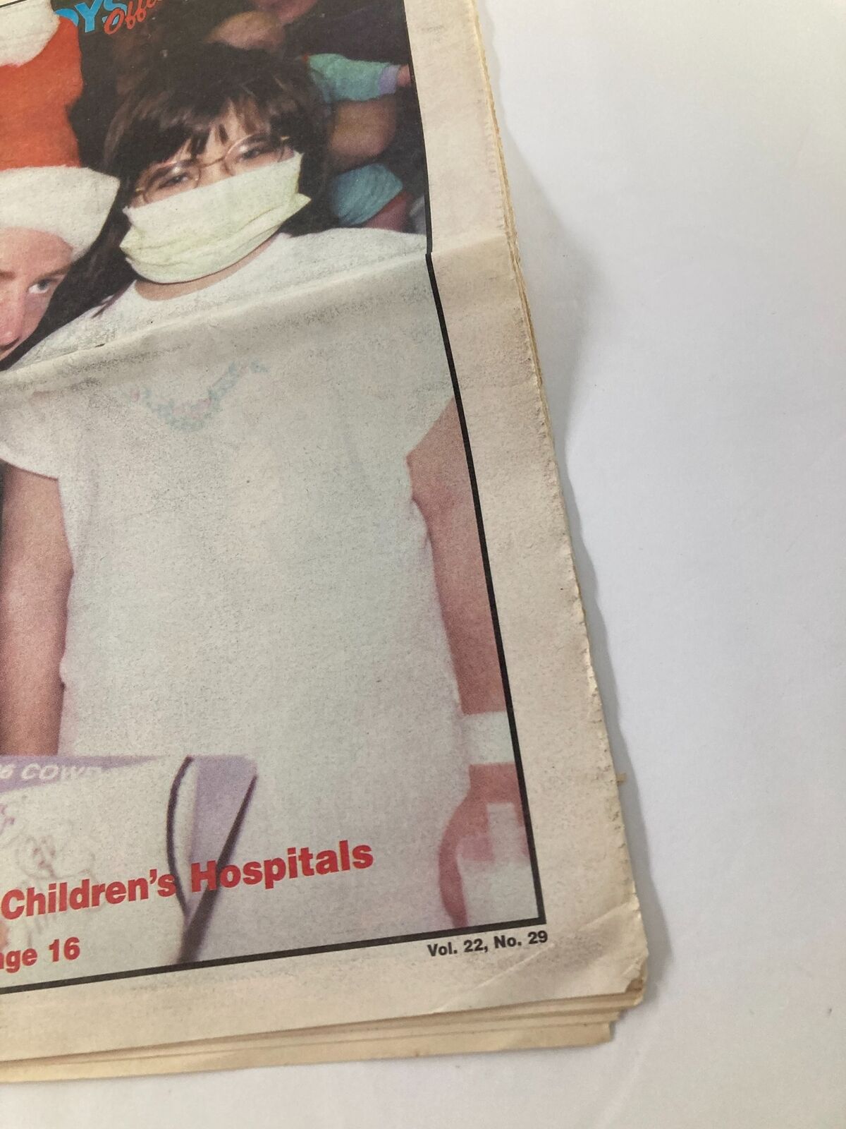 Close-up of Dallas Cowboys Weekly Newspaper December 28 1996 Vol 22 #29 showing a child wearing a mask at a children's hospital event, highlighting the Cowboys' community involvement.
