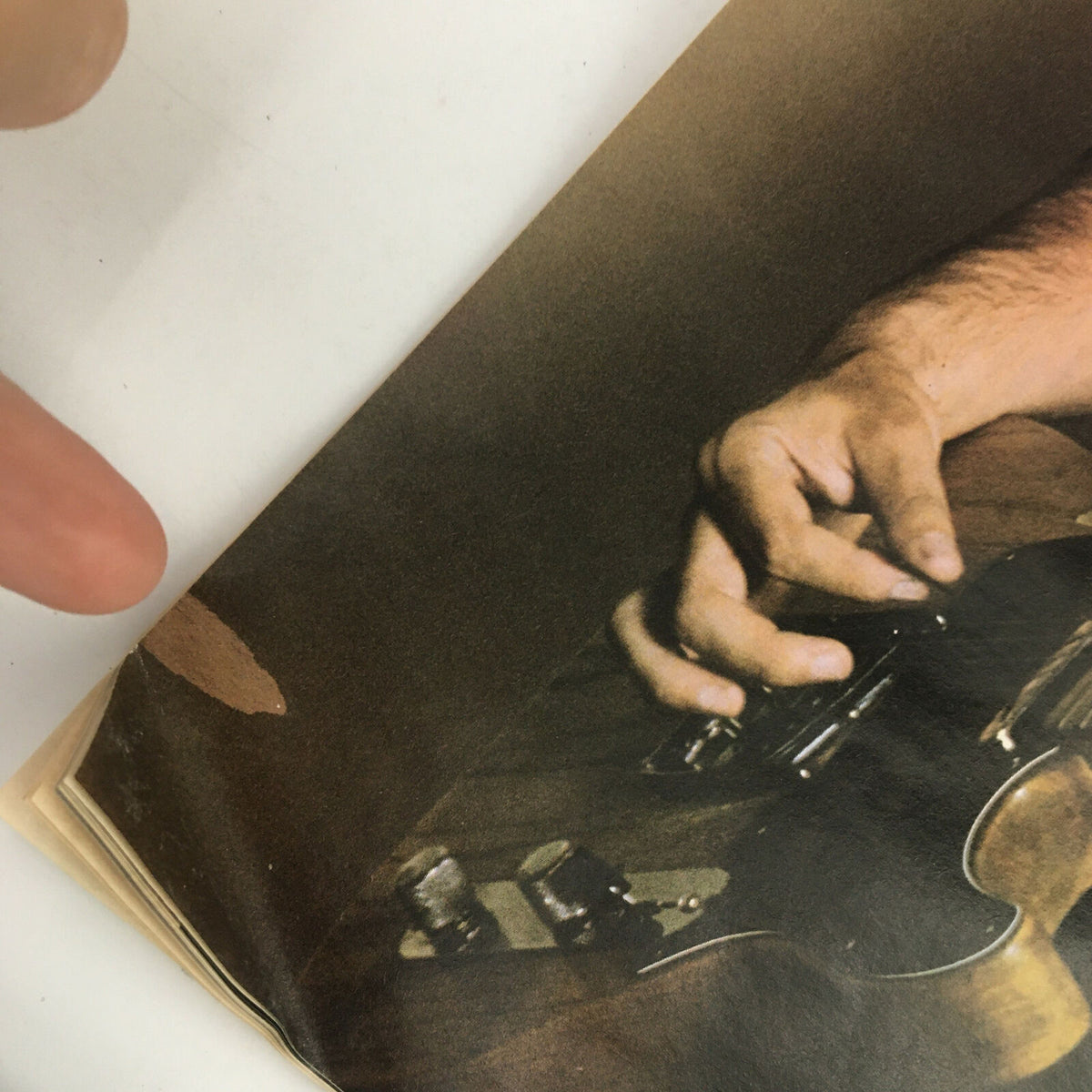 Detailed view of the corner of a page from Circus Magazine December 31 1980, focusing on Bruce Springsteen's guitar and hand positioning.