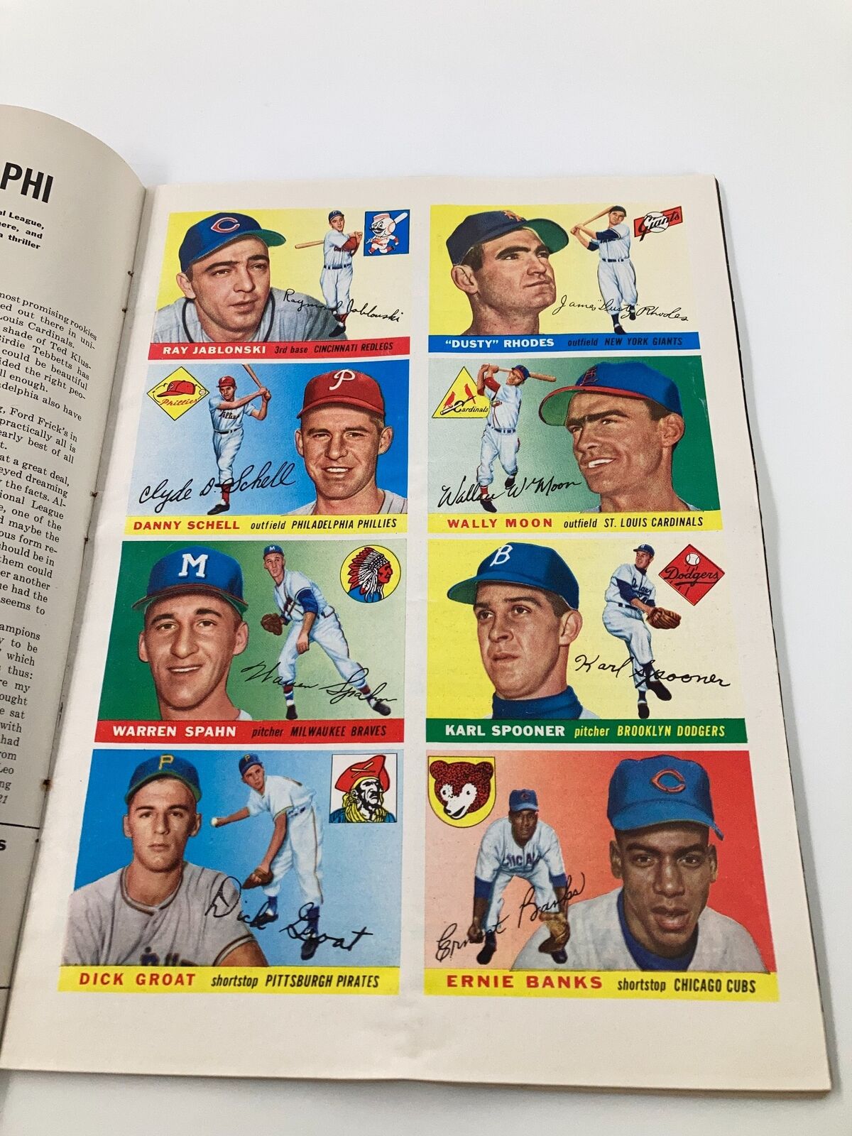 Printed baseball card page from VTG Sports Illustrated Magazine dated April 11, 1955, featuring notable players like Ernie Banks and Warren Spahn, highlighting collectible content from a vintage sports publication.