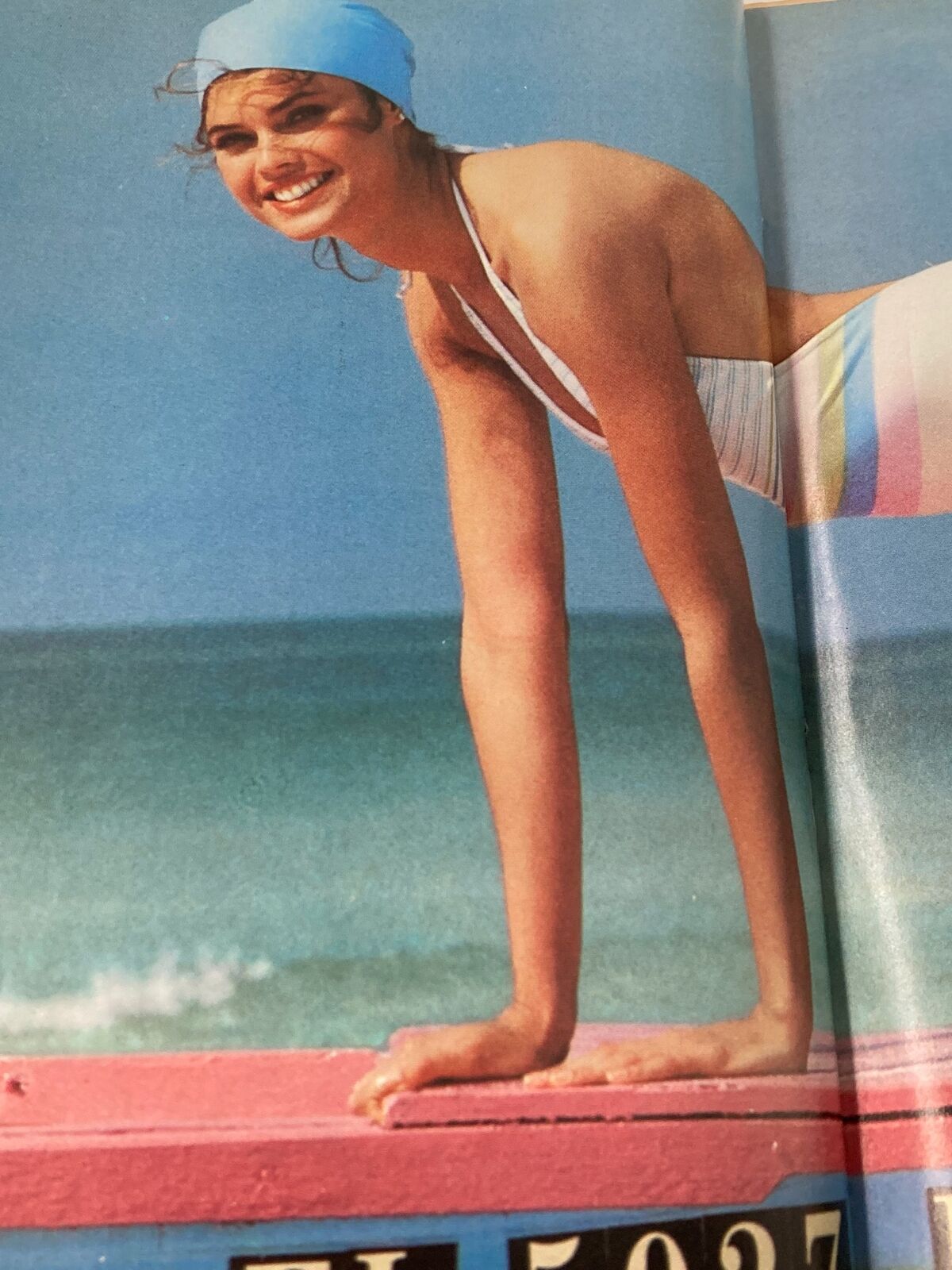 Vintage Sports Illustrated Magazine February 9, 1981 featuring a smiling model in a blue swim cap and striped swimsuit, posing on a surfboard against a beach backdrop.