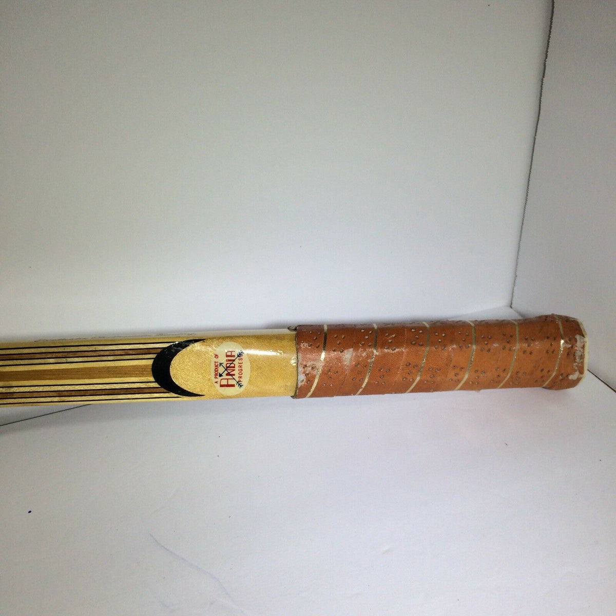 Close-up view of the handle of the Vintage Tournament Wood Tennis Racket Ash Frame 9 Ply Andia, highlighting the grip and detailing.