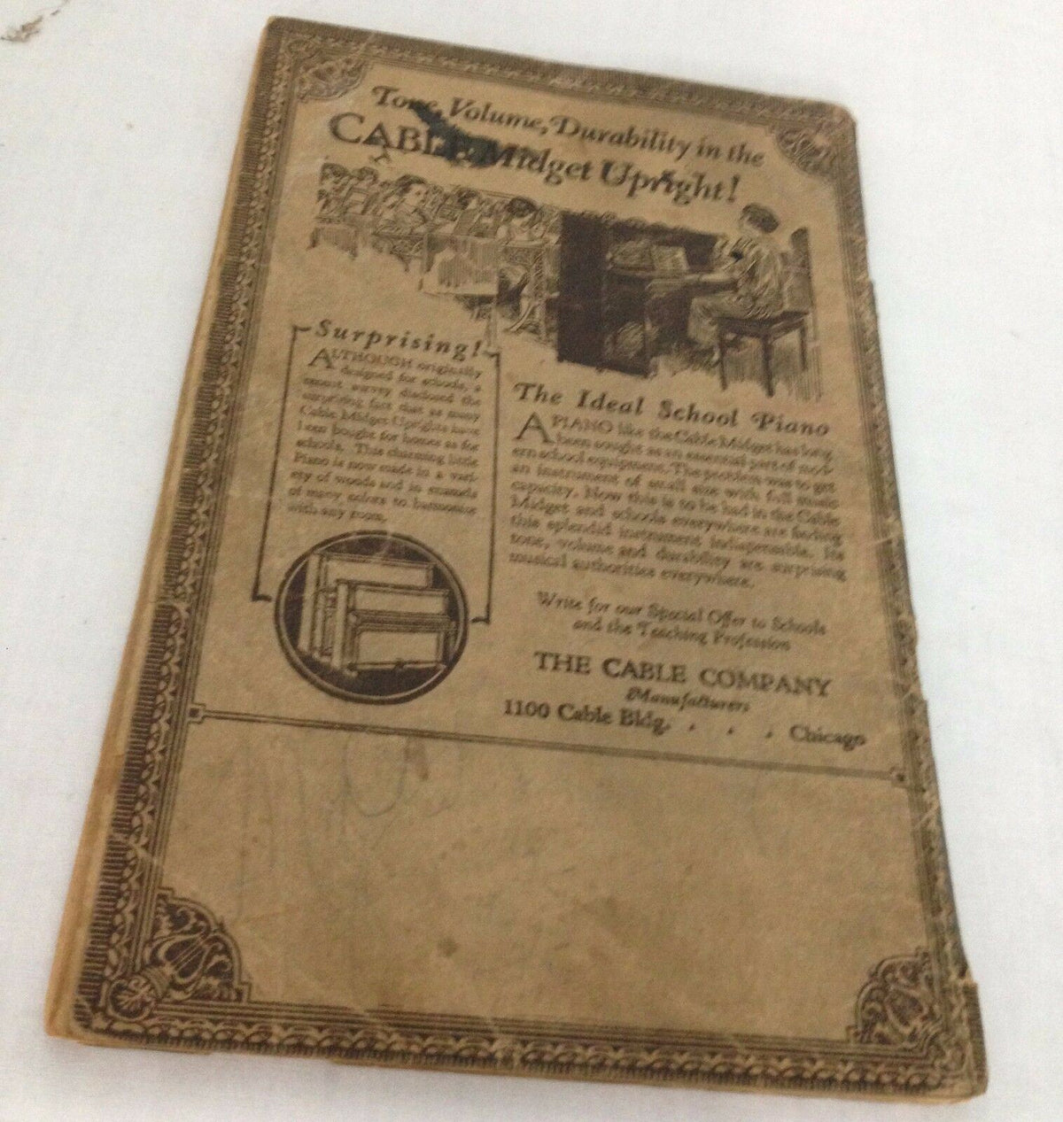 The One Hundred and One Best Songs, 29th Edition, 1927. A vintage image of the back cover featuring advertising for The Cable Company and details about the Cable Midget Upright piano. This historic piece captures the essence of early 20th-century music memorabilia.