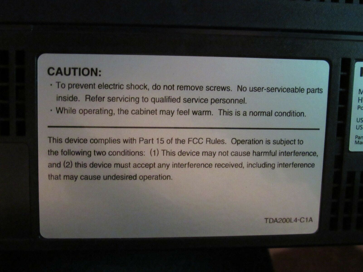 Caution label on the Panasonic KX-TDA50 Hybrid IP-PBX Voicemail Processing System, warning about electric shock and compliance information.