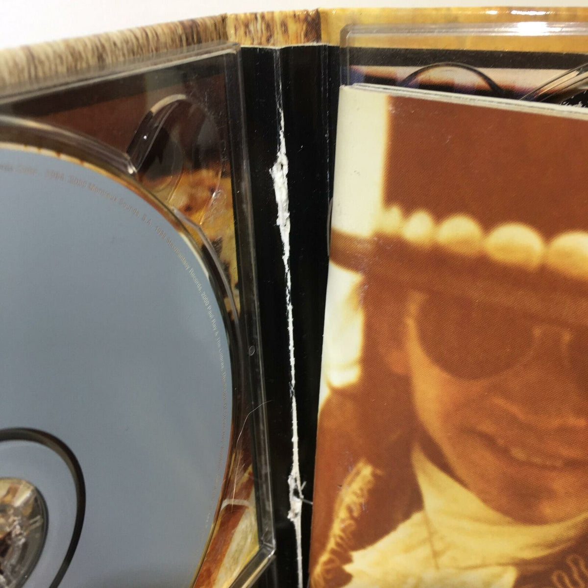Close-up of the spine of Stevie Ray Vaughan And Double Trouble 4 Disc Box Set Audio CD showing minor wear and damage.