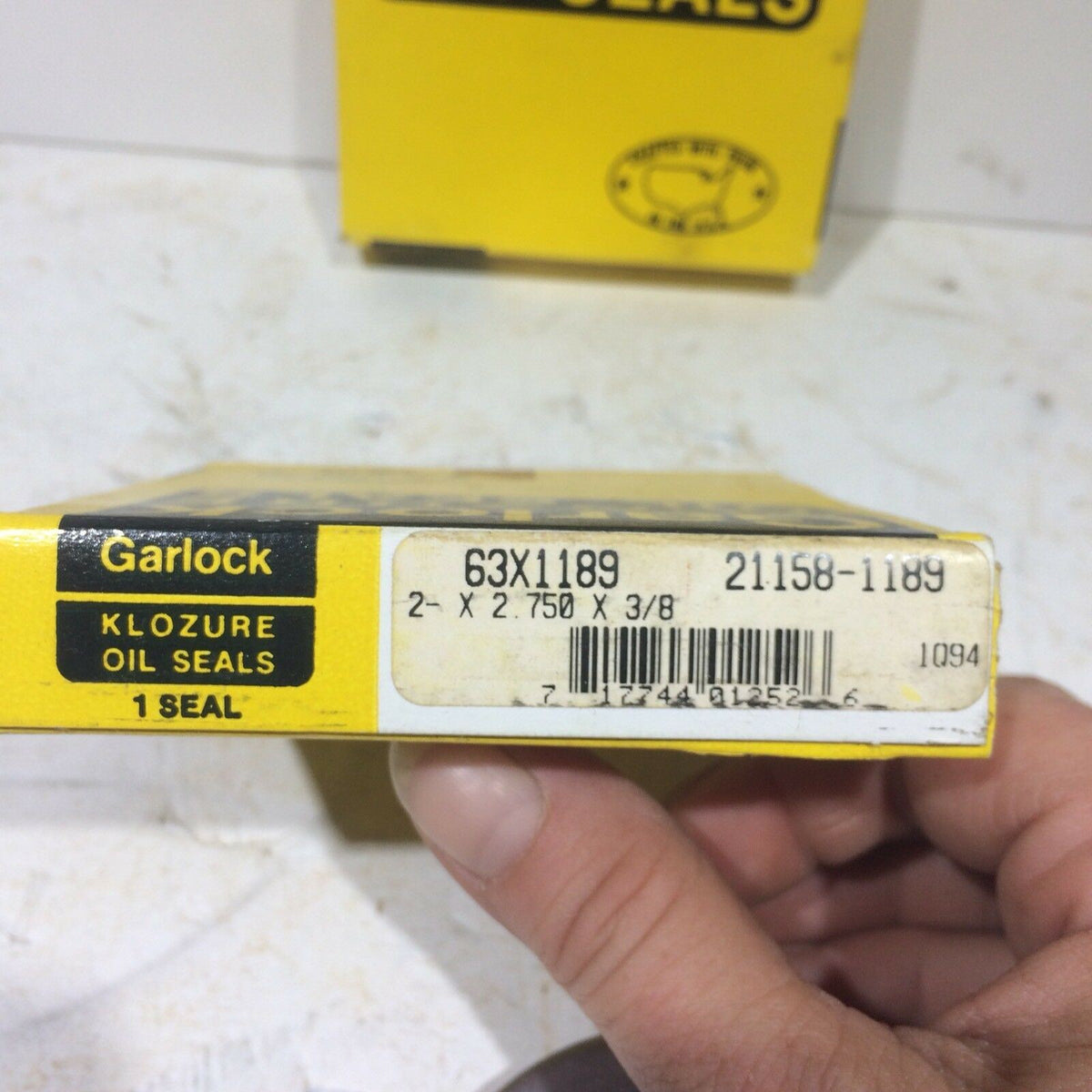 Close-up of the GARLOCK KLOZURE 63X1189 21158-1189 Oil Seal packaging showing detailed specifications, ensuring excellent seal performance against oil and contaminants.