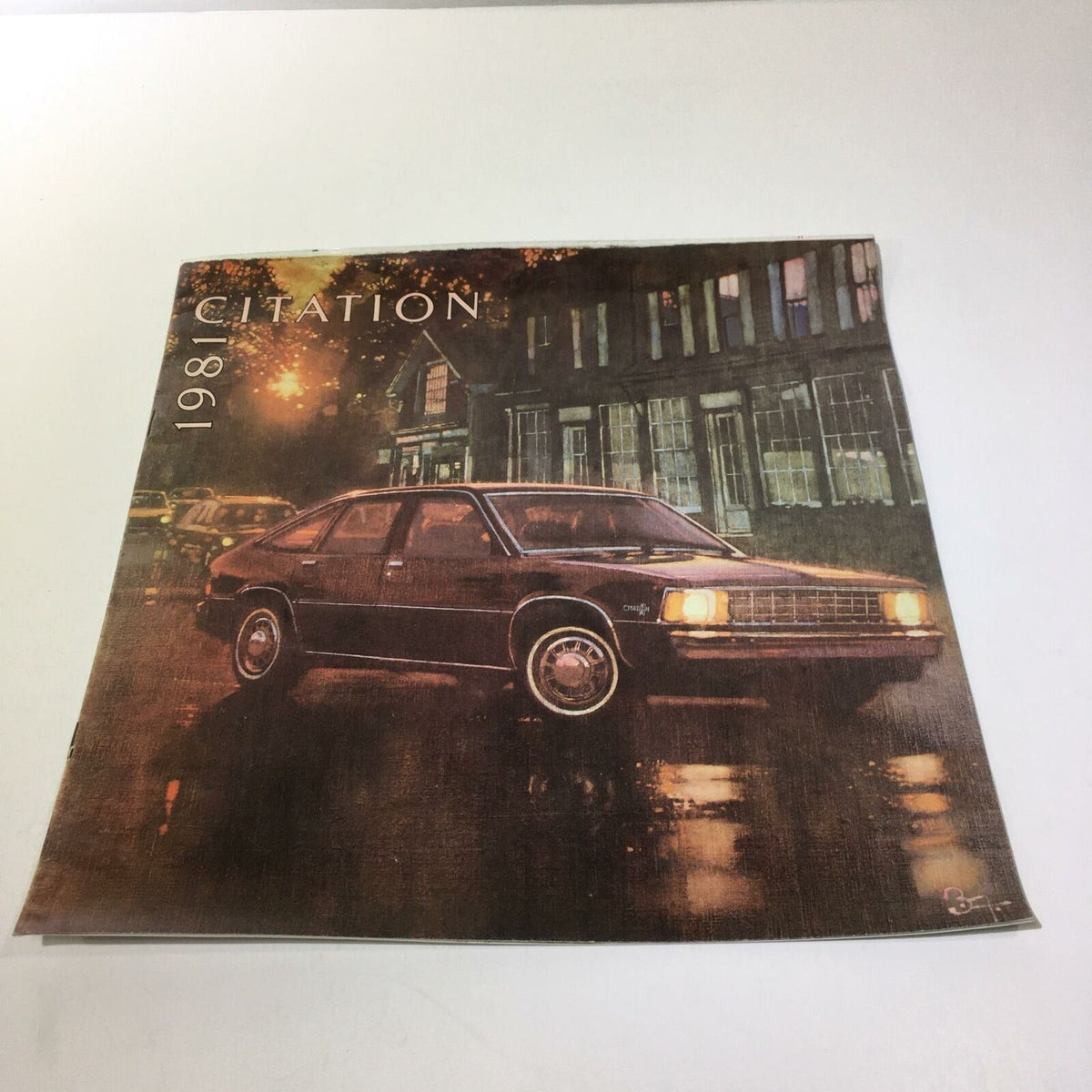 1981 Chevrolet Citation 4-Door Hatchback Sedan Car Sale Brochure cover featuring a dark-colored car parked on a rain-soaked street, showcasing a vintage car design.