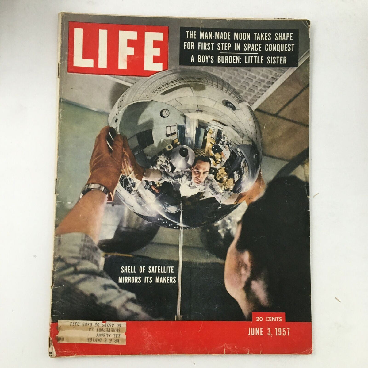 Cover of Life Magazine from June 3, 1957, featuring the topic 'Shell of Satellite & The Man-Made Moon: Space Conquest'. The image showcases a man holding a reflective satellite, capturing a moment in the history of space exploration.
